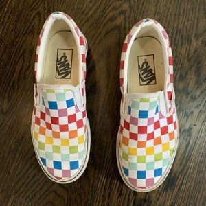 Vans classic slip-ons in rainbow checkerboard.